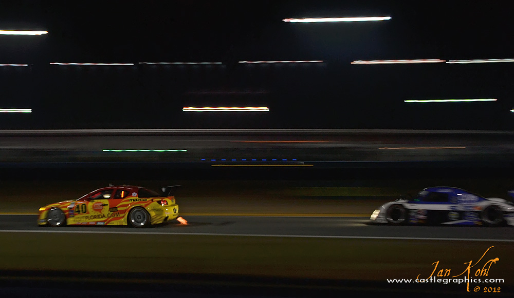 Rolex 24, Nighttime: Flames and flashing...
The #6 Daytona Prototype flashes the headlights as it prepares to dive to the inside of the Dempsey Racing Mazda RX8.
Keywords: 2012 Rolex 24
