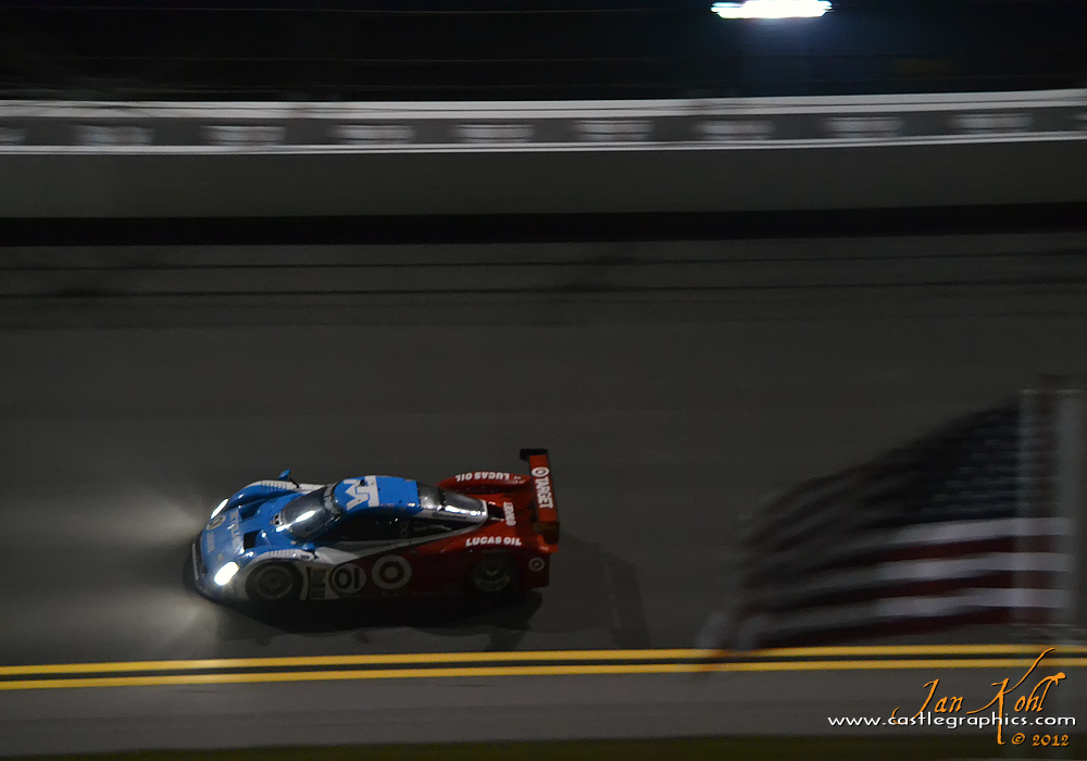 Rolex 24, Nighttime: Ganassi Riley
The #01 car flashes past an American flag mounted on a spectator's RV in the early morning hours.
Keywords: 2012 Rolex 24