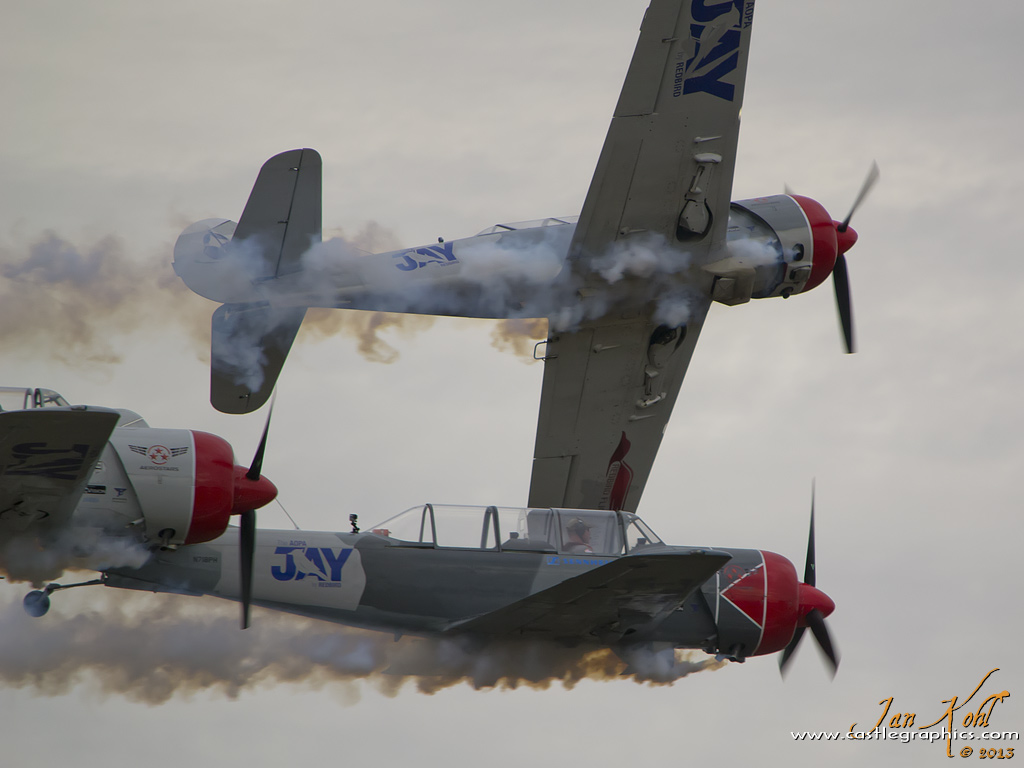 2013-11-09 9536
Peeling away for landing, Team Aerostar's Yak-52 stream smoke under dark skies.
