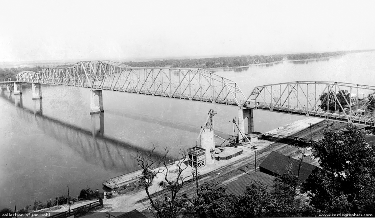 Mark Twain Memorial Bridge
This bridge was started in 1934 and this was probably not too long after it was finished in 1936.  You can see the gravel hopper & crane still there, and a barge in the Mississippi.  This bridge was finally closed in 2000, and dismantled.
