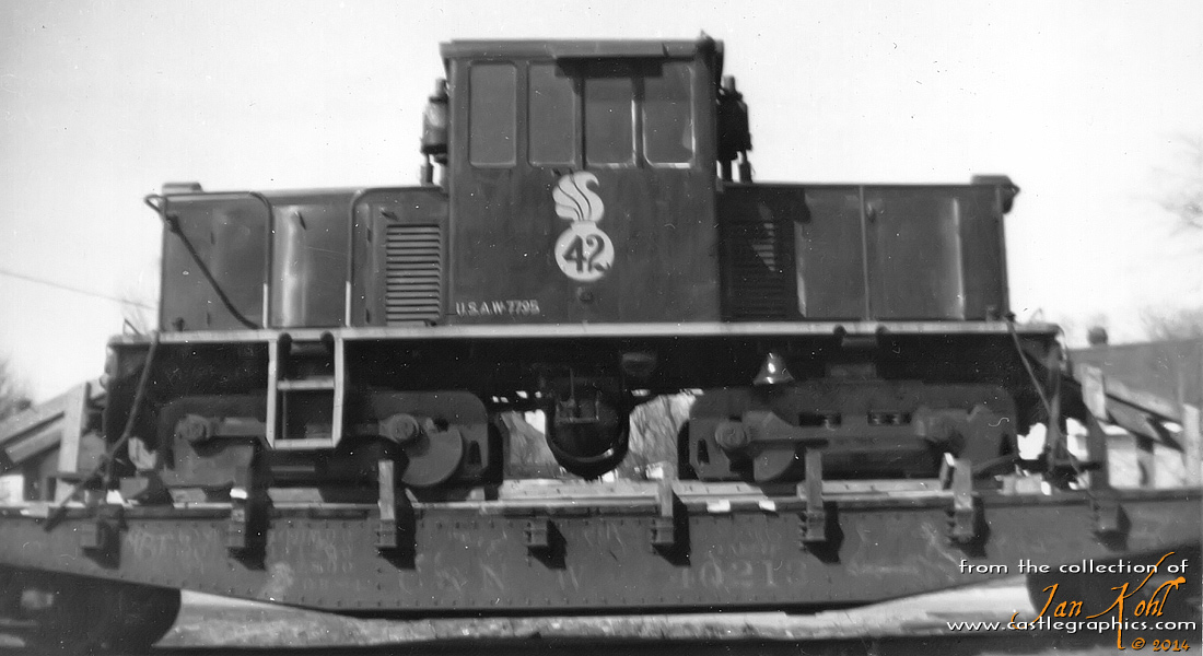 US Army switch engine
A GE 45-ton US Army switch engine sits on a C&NW flatcar.  Tom Mack did some research and found it had been assigned to Kankakee Ordnance Works in Elwood, IL, and then went to Hill AFB in Utah, so it may be in transit between the two locations (probably on the GMO since it went right through Elwood).  The logo on the side is a bomb symbol, commonly found around munitions.  
